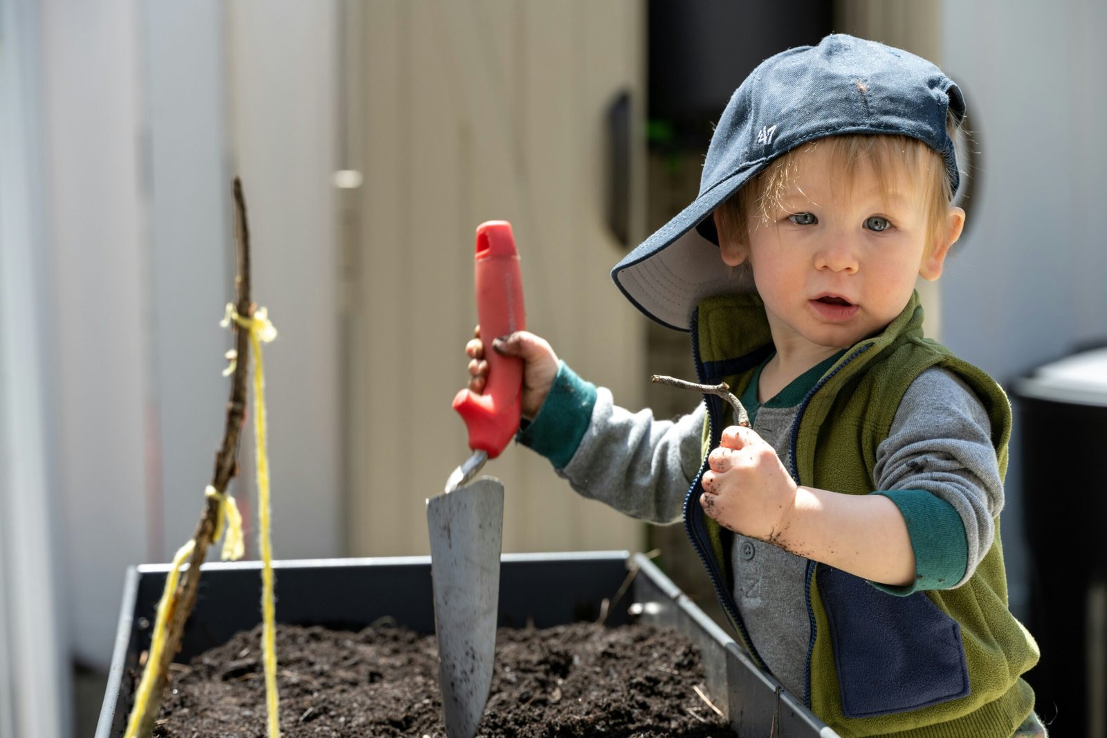 a young boy holding a red shovel